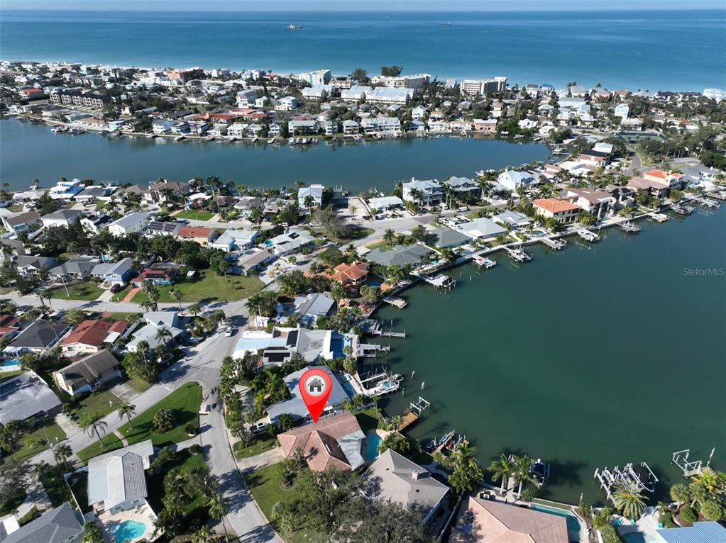 An aerial view shows a waterfront house with a pool and dock on a canal — 410 HARBOR DRIVE N, INDIAN ROCKS BEACH, FL
