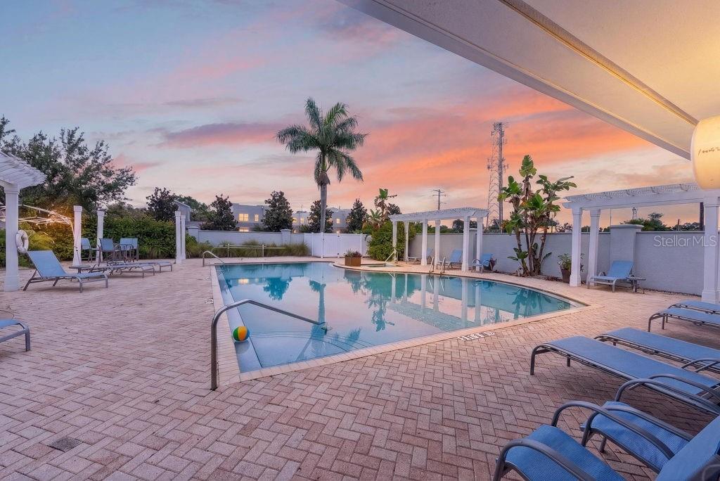A swimming pool with lounge chairs on a brick patio at sunset — 4546 BAY SPRING COURT, TAMPA, FL