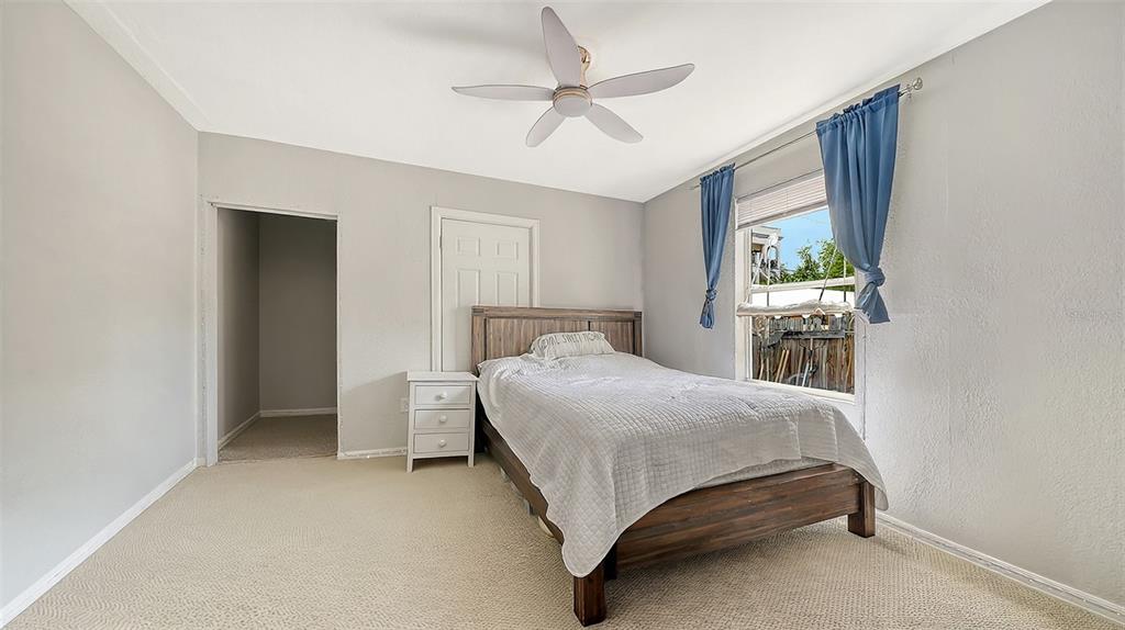 A bedroom features a wooden bed frame, a white nightstand, and a ceiling fan — 420 KUMQUAT COURT, SARASOTA, FL