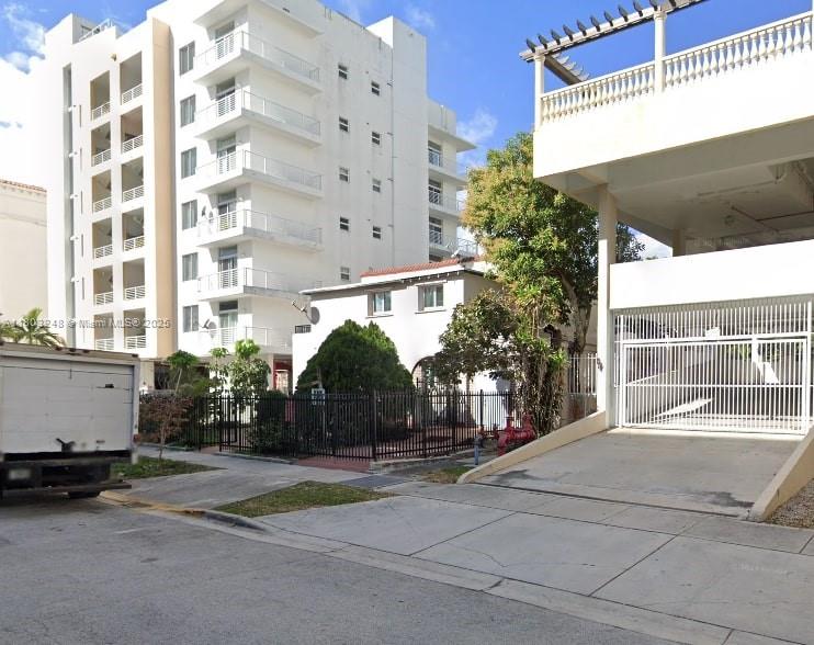 A white multi-story apartment building stands next to a smaller house and a parking structure — 437 NE 30th St, Miami FL 33137, MIAMI, FL