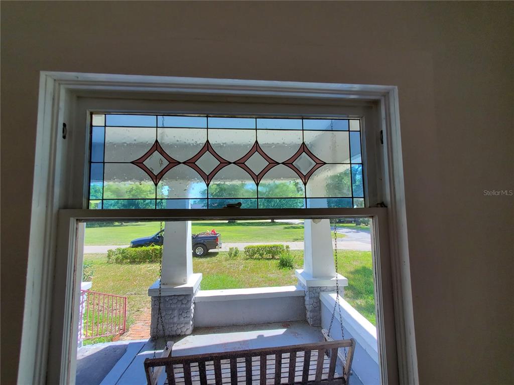 A view from inside looking out through a window with a decorative stained glass transom — 23882 NW 187TH AVENUE, HIGH SPRINGS, FL