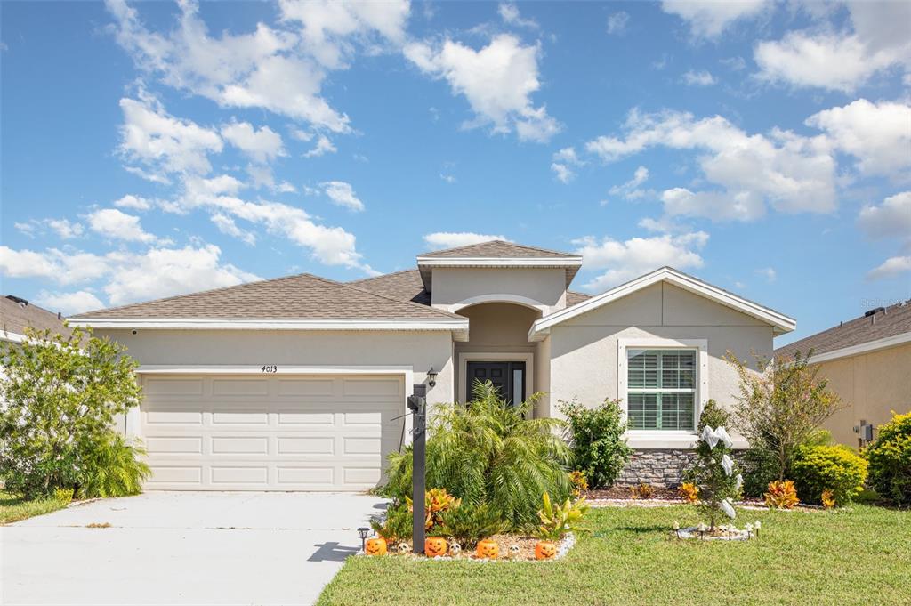A single-story house with a two-car garage, stone accents, and a landscaped front yard — 4013 LIVELY CORAL PLACE, BRADENTON, FL