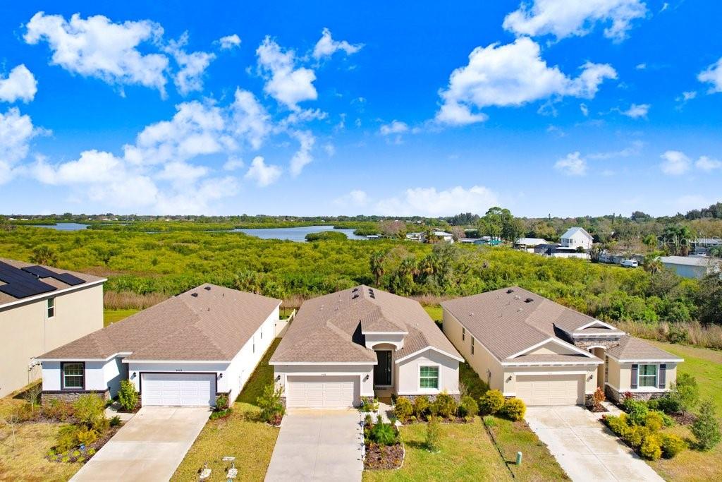 A dark gray front door with a side window is set in a recessed entryway — 4013 LIVELY CORAL PLACE, BRADENTON, FL