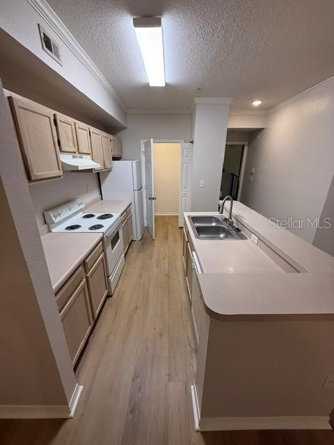 A kitchen features light wood cabinets, white appliances, a breakfast bar, and light-colored flooring — 5608 PINNACLE HEIGHTS CIRCLE UNIT 307, TAMPA, FL