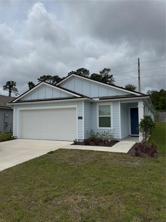 A light blue, single-story house with a two-car garage and a dark blue front door — 203 CHESTERWOOD ROAD, ST AUGUSTINE, FL