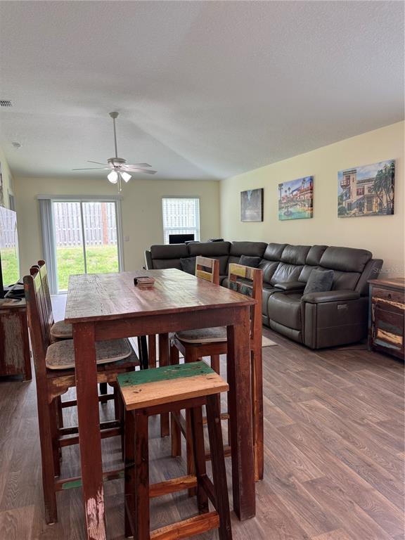 A dining area with a wooden table and stools sits in front of a living room — 203 CHESTERWOOD ROAD, ST AUGUSTINE, FL