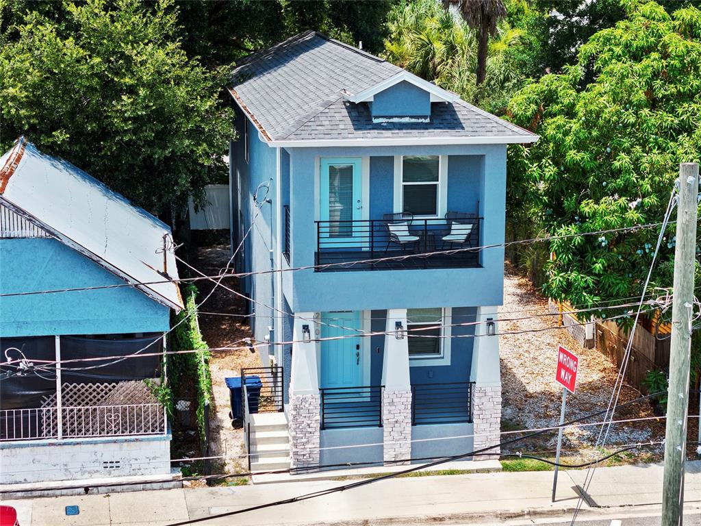 An aerial view of a two-story blue house with a front balcony and stone accents — 2106 E 17TH AVENUE, TAMPA, FL