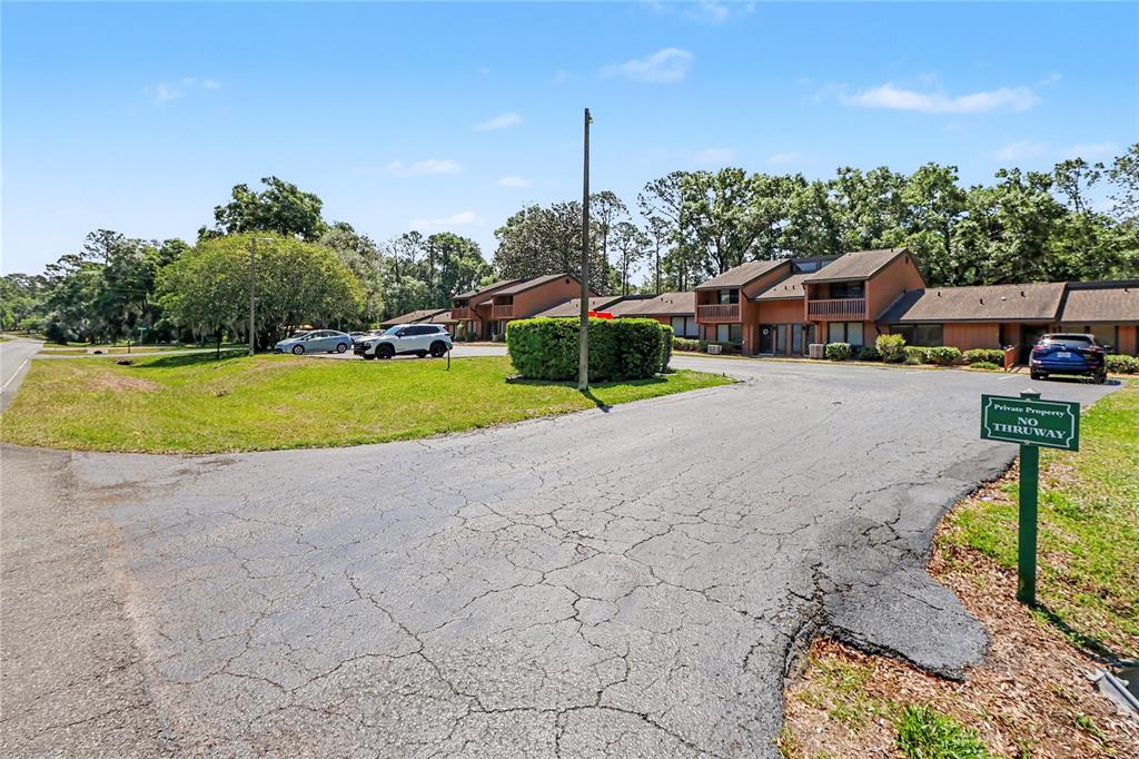 An exterior view of a multi-unit residential building with a paved parking lot — 19660 SW 83RD PLACE ROAD UNIT C16, DUNNELLON, FL