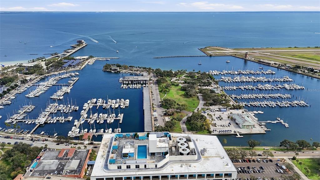An aerial view shows a marina with many boats, a park, and a large building — 1 BEACH DRIVE SE UNIT 1610, ST PETERSBURG, FL