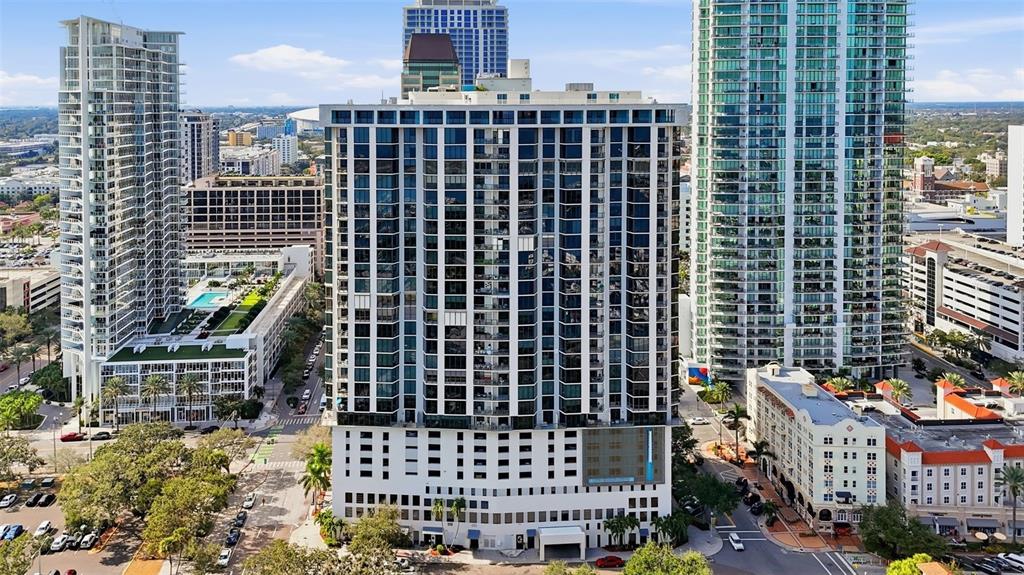 An aerial view of a tall residential building surrounded by other high-rise structures and streets — 1 BEACH DRIVE SE UNIT 1610, ST PETERSBURG, FL