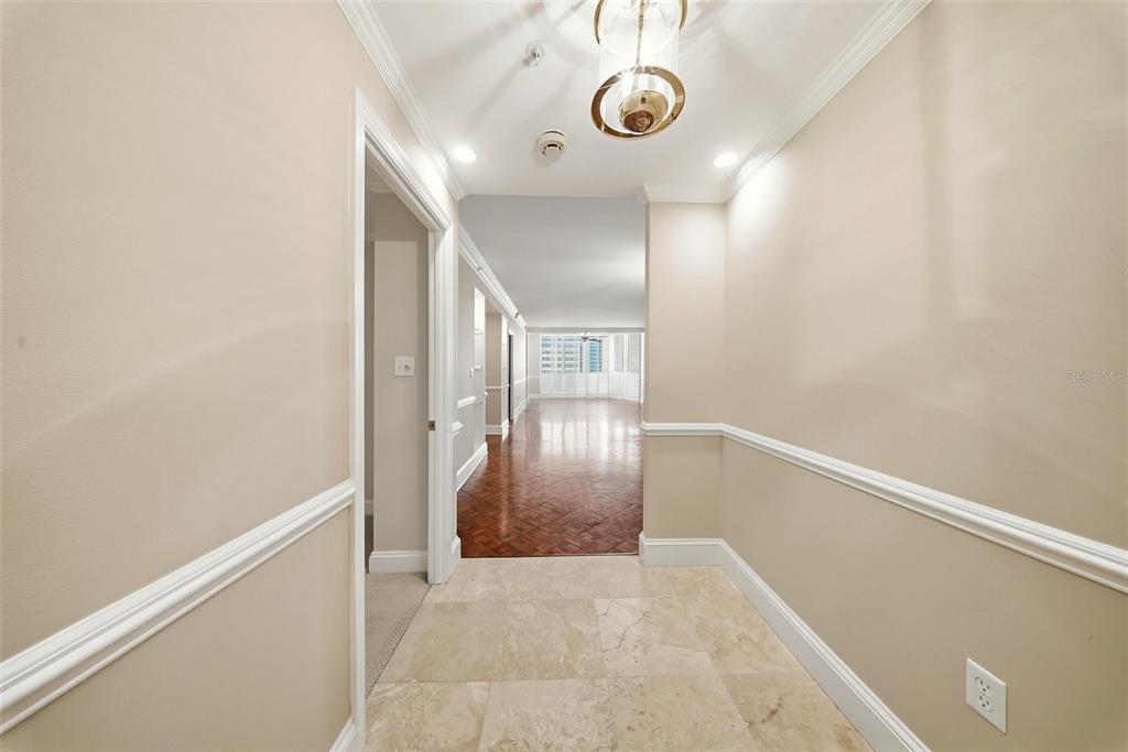 A tiled entryway leads into a living area with hardwood floors and crown molding — 1 BEACH DRIVE SE UNIT 1610, ST PETERSBURG, FL