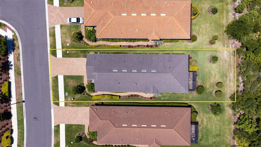 An aerial view shows a house with a gray roof centered between two neighboring homes — 3254 FRANCOA DRIVE, ODESSA, FL
