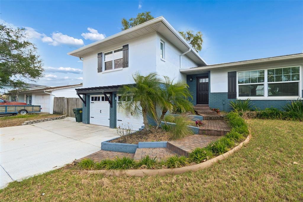 A two-story house with a white facade, blue brick base, and a brick walkway — 13548 BELLEWOOD AVENUE, SEMINOLE, FL