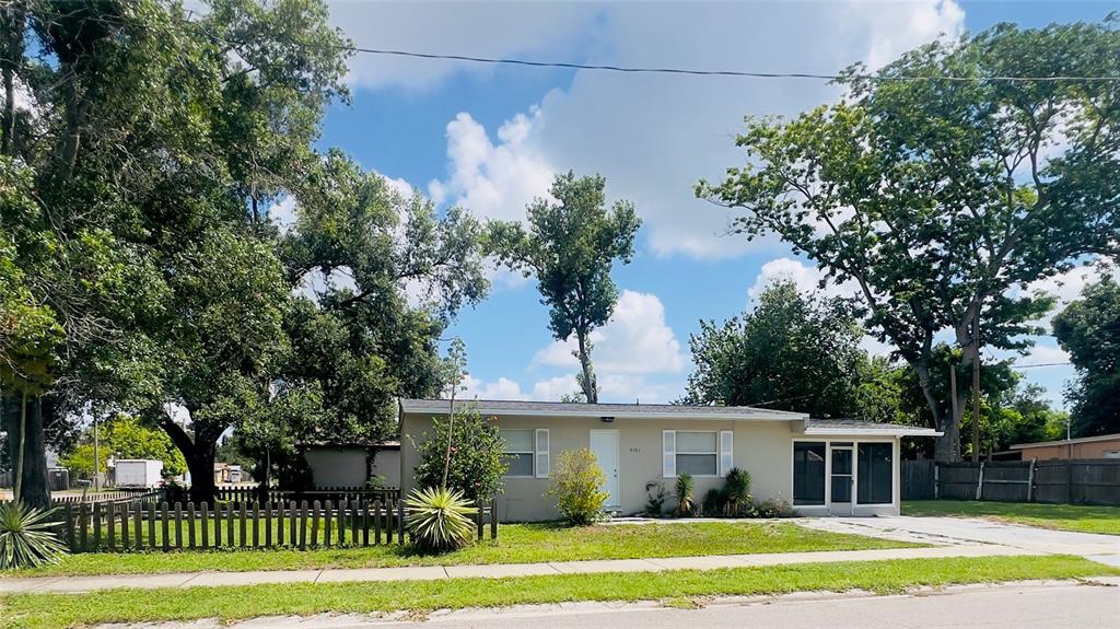 The exterior of a single-story house features a large, screened-in front porch — 5301 40TH STREET N, ST PETERSBURG, FL