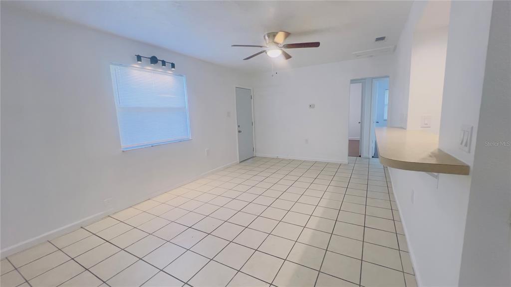 A kitchen features white cabinets, a stainless steel refrigerator, and light-colored tile flooring — 5301 40TH STREET N, ST PETERSBURG, FL