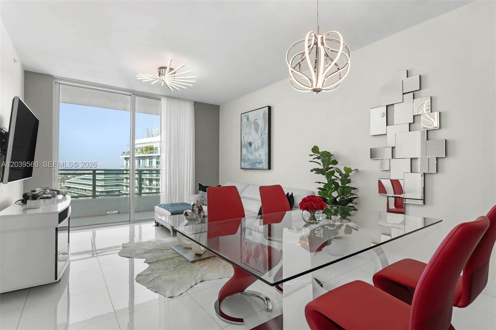 A modern dining and living area features a glass table, red chairs, and balcony access — 1080 Brickell Ave # 4103, Miami FL 33131, MIAMI, FL