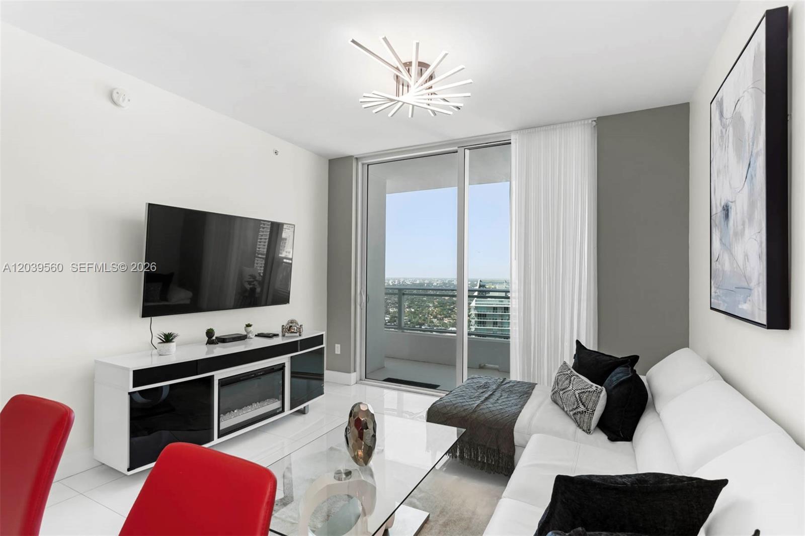 A modern living room features a white sofa, glass coffee table, and a balcony view — 1080 Brickell Ave # 4103, Miami FL 33131, MIAMI, FL