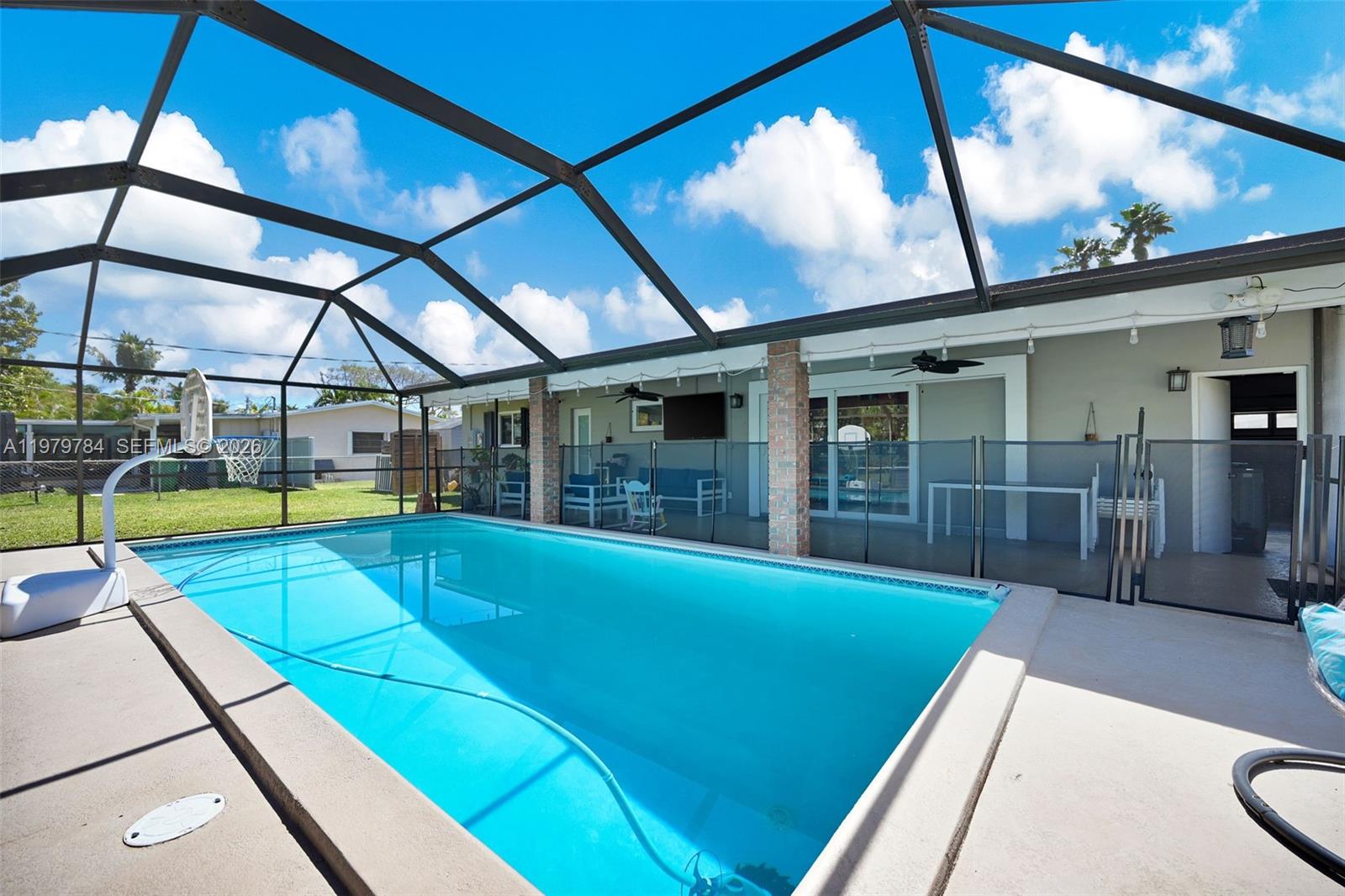 A rectangular swimming pool is enclosed by a screened lanai with a patio area — 8935 SW 186th Ter, Cutler Bay FL 33157, CUTLER BAY, FL