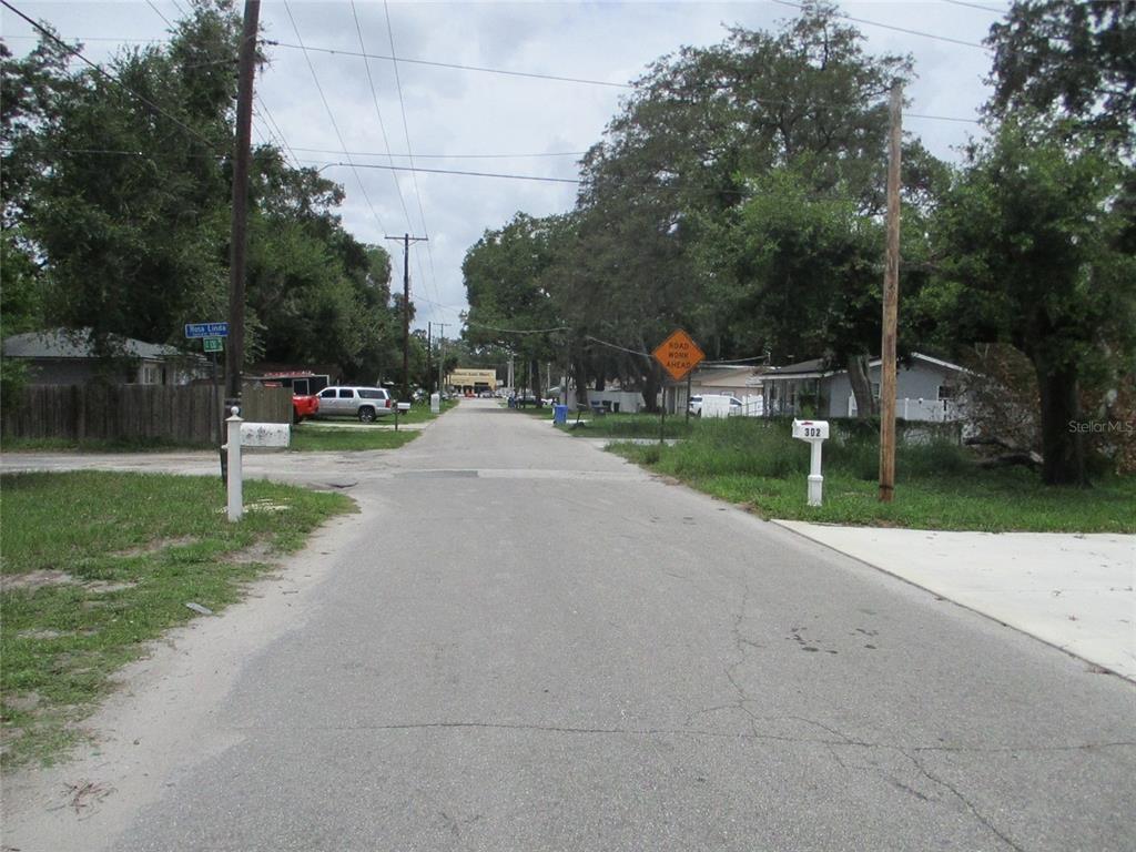 A paved residential street features a road work sign and mailboxes on a cloudy day — 302 E 130TH AVENUE, TAMPA, FL