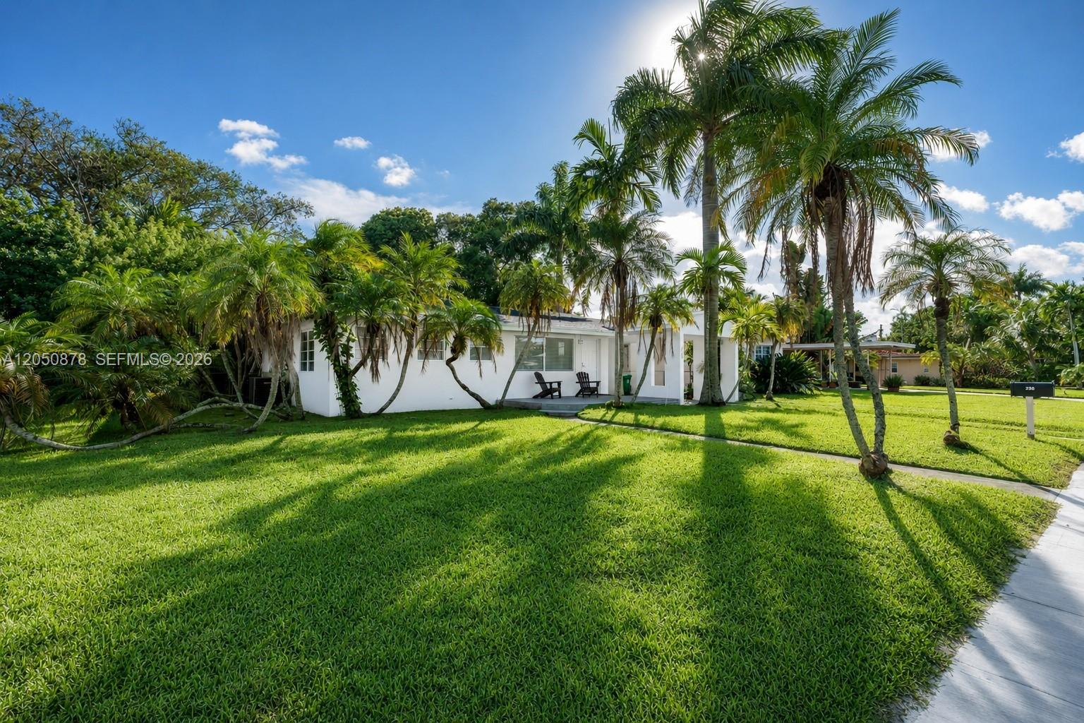 A white single-story house with palm trees and a large lawn under a sunny sky — 230 NE 2nd Pl, Dania Beach FL 33004, DANIA BEACH, FL