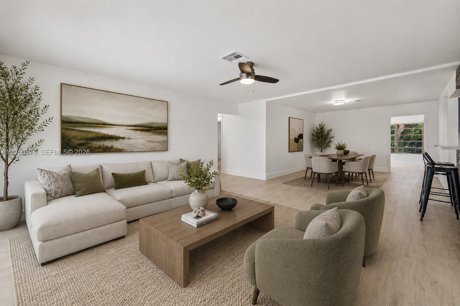 A bright living room and dining area feature light wood floors, neutral furniture, and artwork — 230 NE 2nd Pl, Dania Beach FL 33004, DANIA BEACH, FL