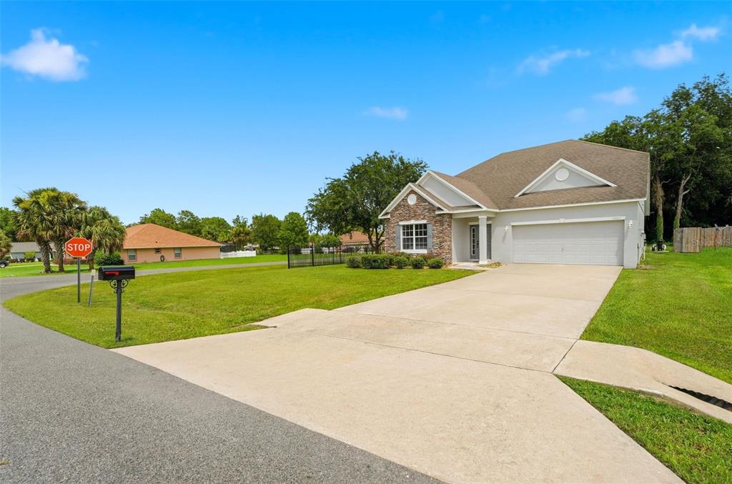 A single-story suburban house with a stone facade, a two-car garage, and a concrete driveway — 11661 SW 56TH TERRACE, OCALA, FL