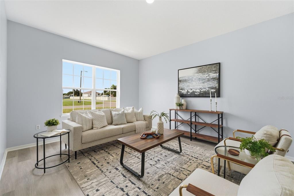 A living room features a beige sofa, wooden coffee table, and two chairs on a rug — 11661 SW 56TH TERRACE, OCALA, FL
