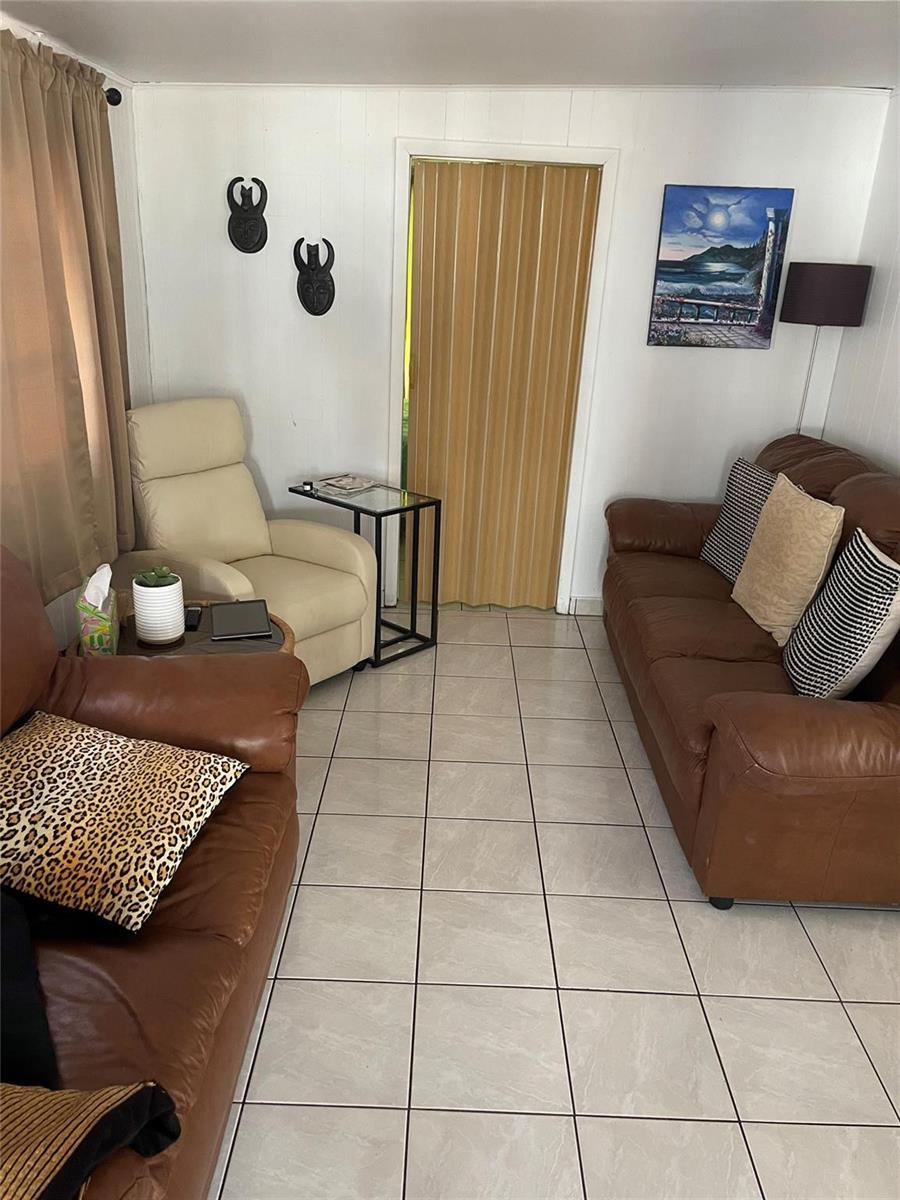 A living room features tile floors, a brown leather sofa, and a cream-colored recliner — 8610 SW 18th Court, Davie FL 33324, DAVIE, FL