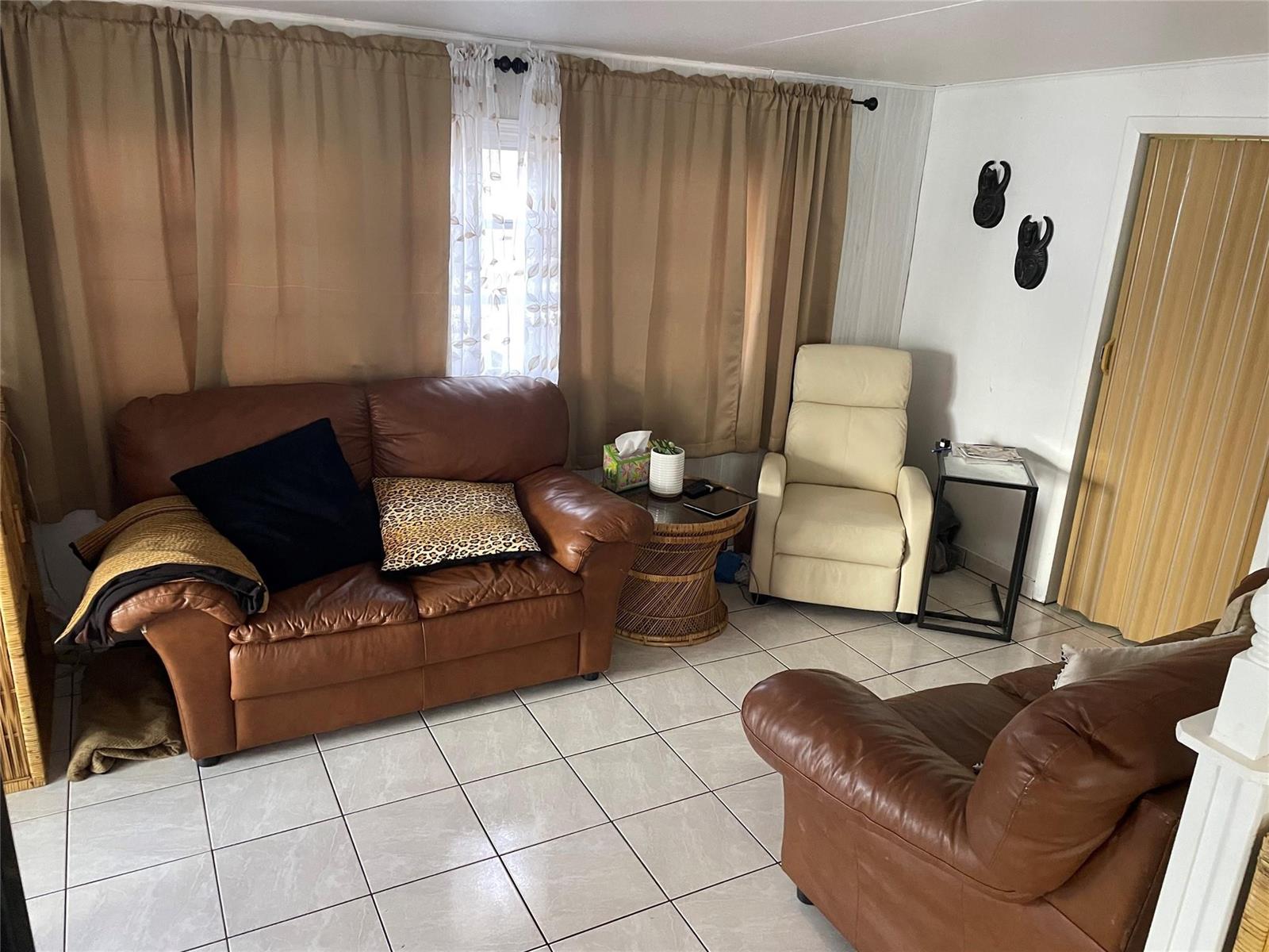 A living room features tiled floors, two brown leather sofas, and a cream-colored recliner — 8610 SW 18th Court, Davie FL 33324, DAVIE, FL