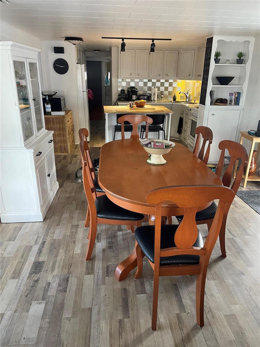 A dining area with a wooden table and chairs sits in front of a kitchen — 8610 SW 18th Court, Davie FL 33324, DAVIE, FL