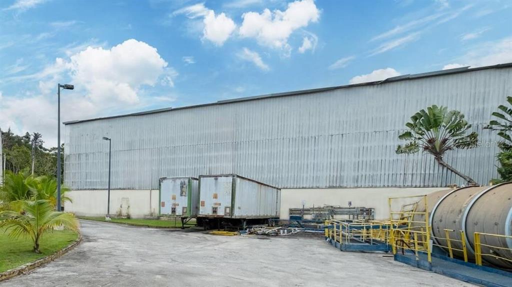 An exterior view of a large industrial warehouse building with two parked semi-trailers — Calle 2 PR-7731 INT PR 171, CIDRA, PR