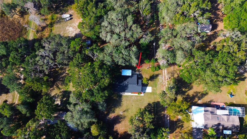 An aerial view shows a house with a dark roof surrounded by dense trees — 8807 OVERLOOK DRIVE, WESLEY CHAPEL, FL