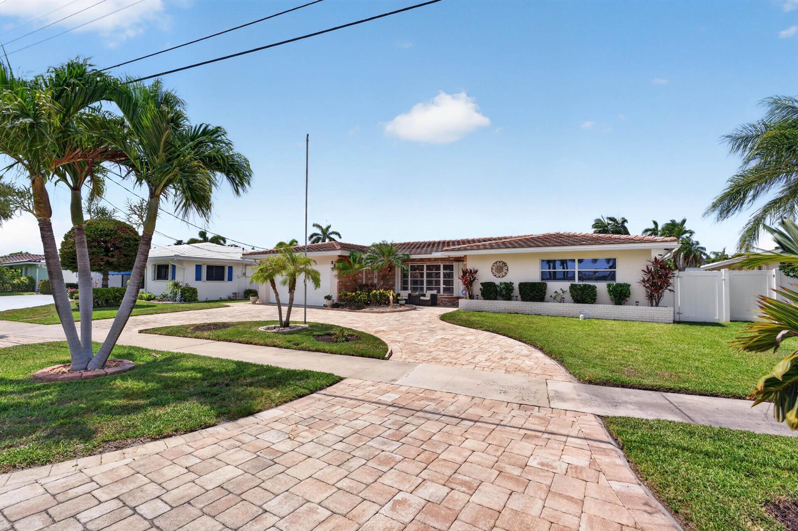 A single-story house with a paved driveway, palm trees, and a manicured lawn — 1517 SE 14TH Street, Deerfield Beach FL 33441, DEERFIELD BEACH, FL