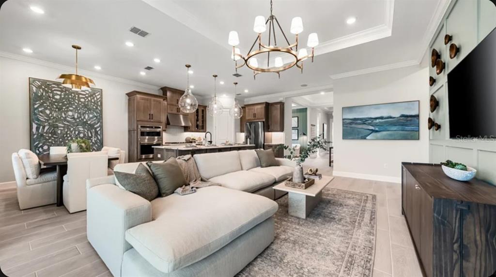 A kitchen island with dark cabinets and a light countertop sits before a walk-in pantry — 7700 BLUE MOON RUN, SARASOTA, FL