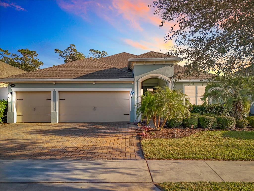 A single-story house with a two-car garage and a paved driveway at sunset — 295 NORTHCOTE COURT, DELAND, FL