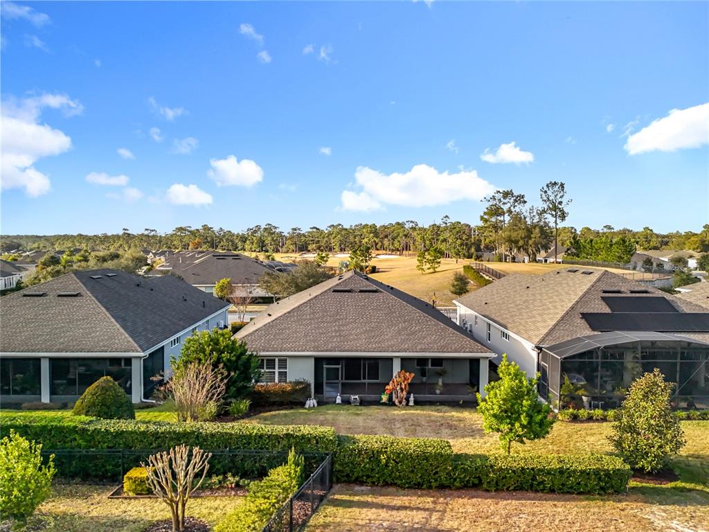 An aerial view shows the back of three suburban houses with screened lanais and landscaping — 295 NORTHCOTE COURT, DELAND, FL