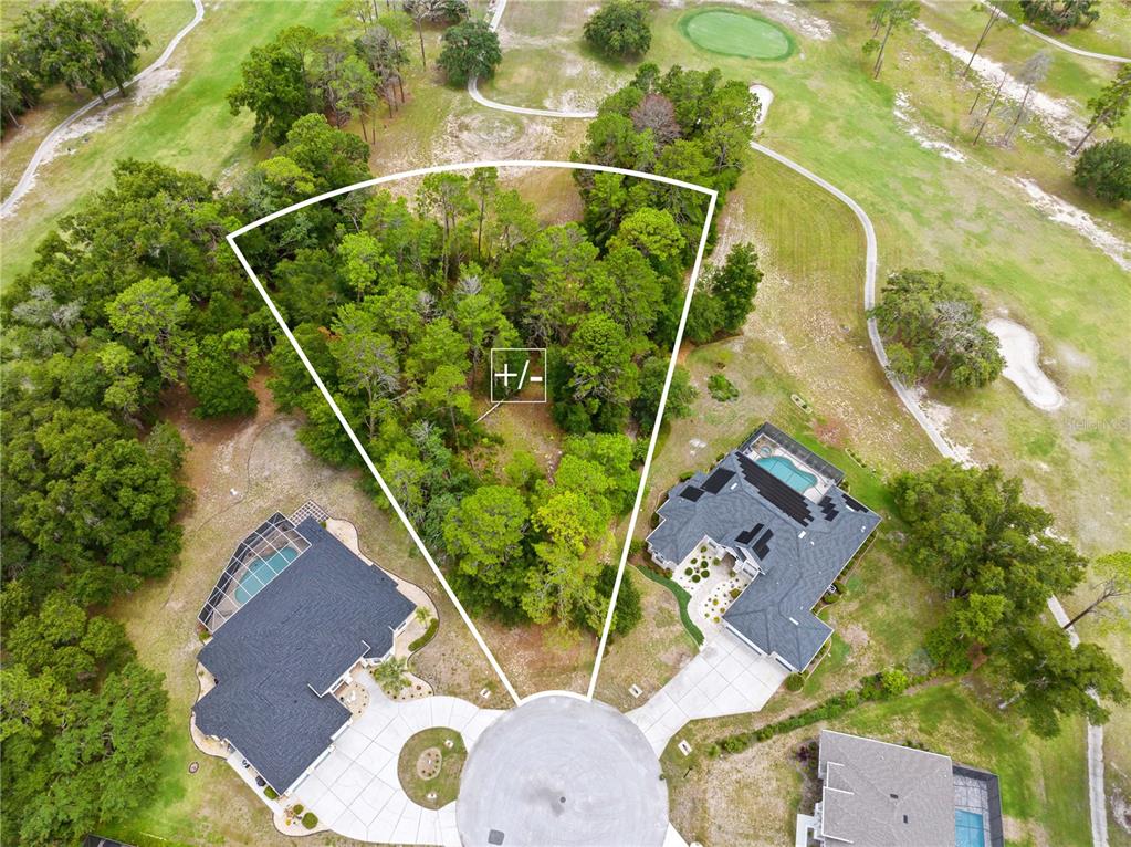 An aerial view shows a vacant, wooded residential lot situated between two houses on a cul-de-sac — 17 WOODLEE COURT S, HOMOSASSA, FL
