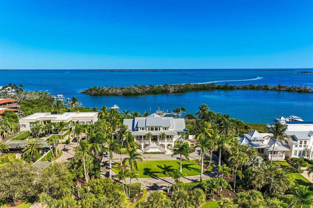 An aerial view shows a large waterfront house with a lawn and palm trees — 4070 LOOMIS AVENUE, BOCA GRANDE, FL