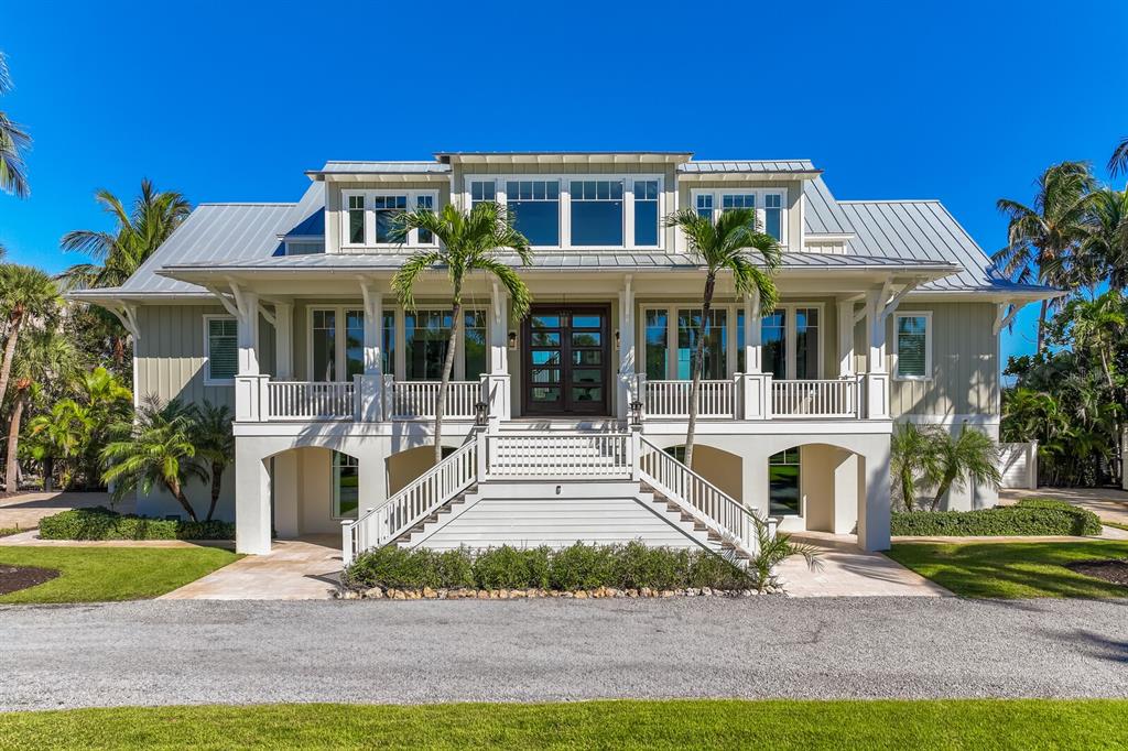 A two-story coastal house with a metal roof, elevated porch, and central staircase — 4070 LOOMIS AVENUE, BOCA GRANDE, FL