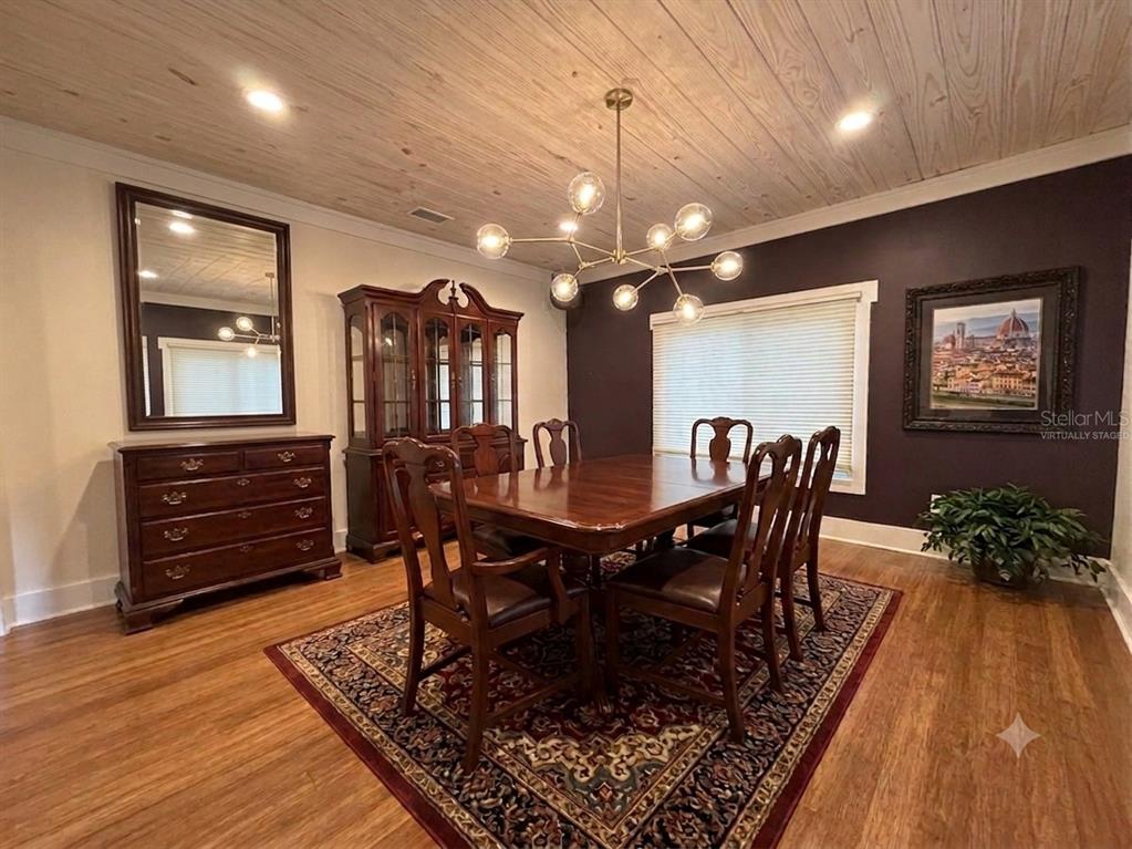 A dining room features a wooden table, chairs, a hutch, a mirror, and a wood-plank ceiling — 301 E KENTUCKY AVENUE, DELAND, FL