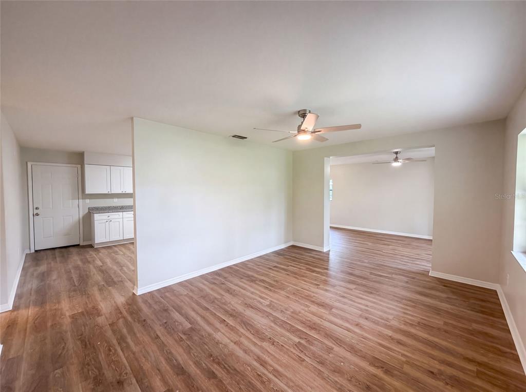 An interior view shows a living area with wood-look flooring and a ceiling fan — 6520 NW 61ST COURT, OCALA, FL