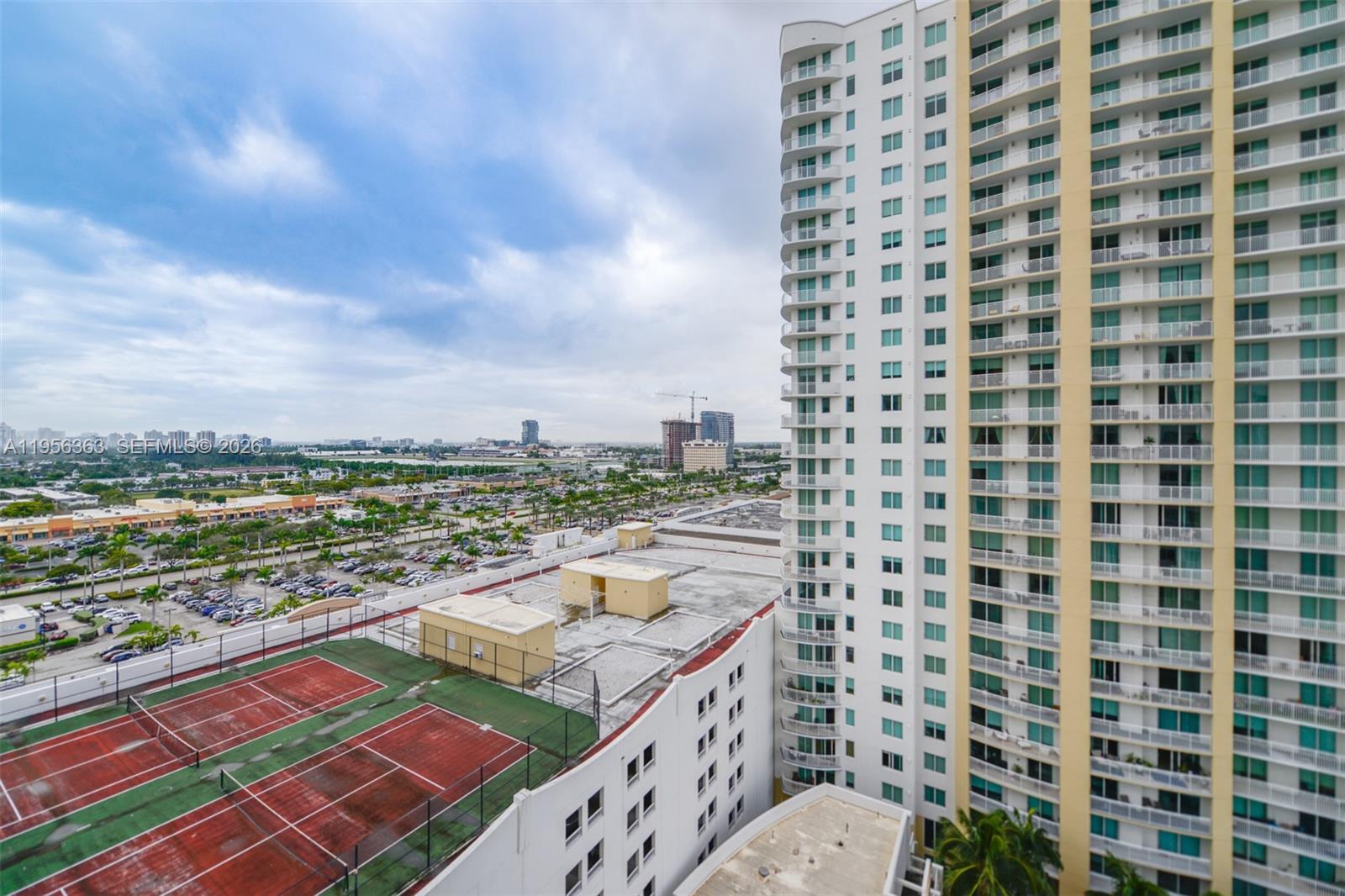 An elevated view shows a tennis court next to a tall residential high-rise building — 1755 E Hallandale Beach Blvd # 1408E, Hallandale Beach FL 33009, HALLANDALE BEACH, FL