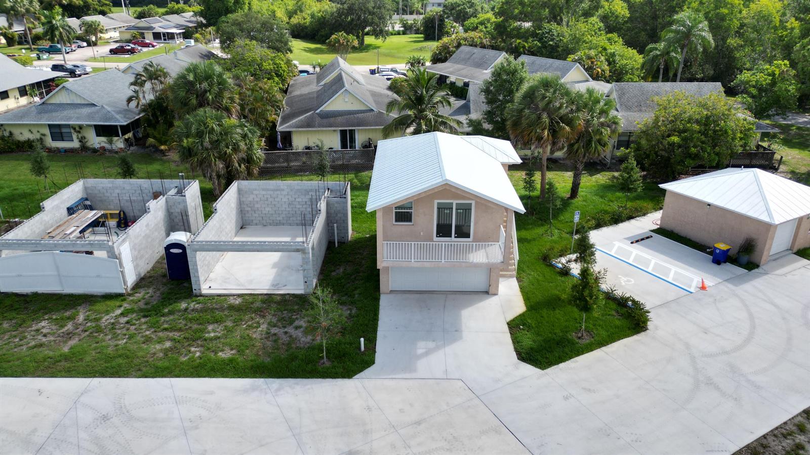 An aerial view shows a two-story house, an adjacent concrete block structure, and a garage — 0 SE Morningside Drive, FL 34997, FL
