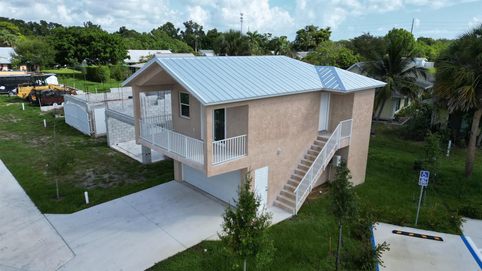 An elevated two-story structure with a metal roof, exterior staircase, balcony, and ground-level garage — 0 SE Morningside Drive, FL 34997, FL