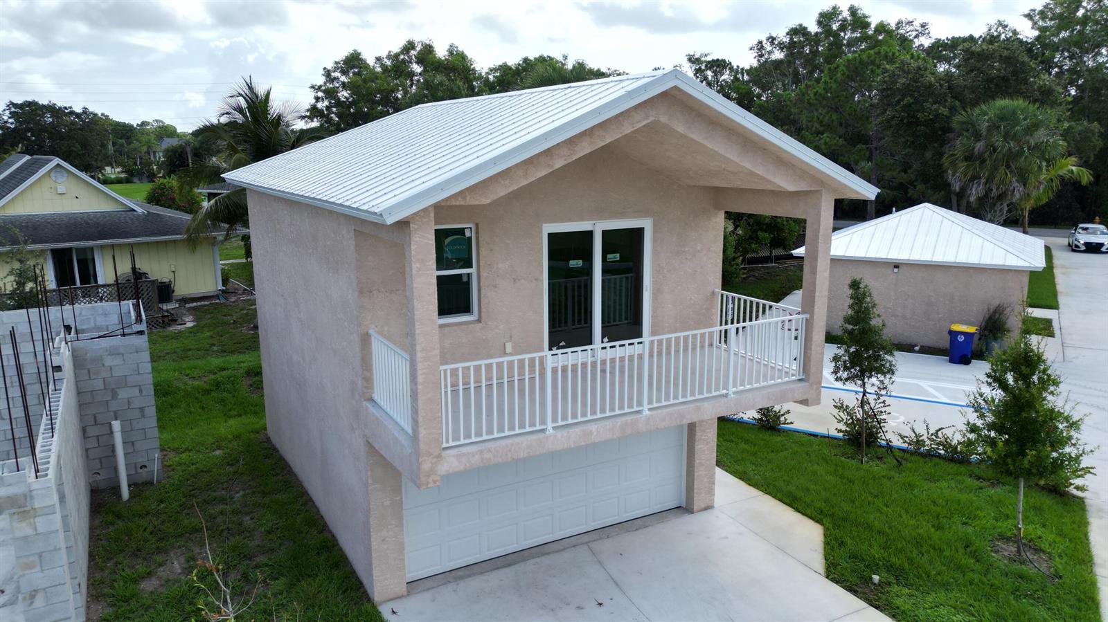 An elevated view of a two-story structure with a garage, balcony, and metal roof — 0 SE Morningside Drive, FL 34997, FL