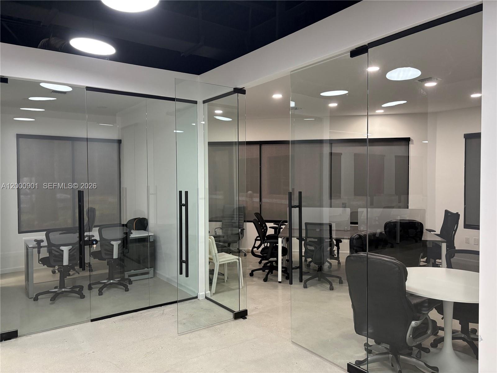 Modern office space features glass-walled conference rooms with black frames and concrete flooring — 1545 N Park Dr, Weston FL 33326, WESTON, FL