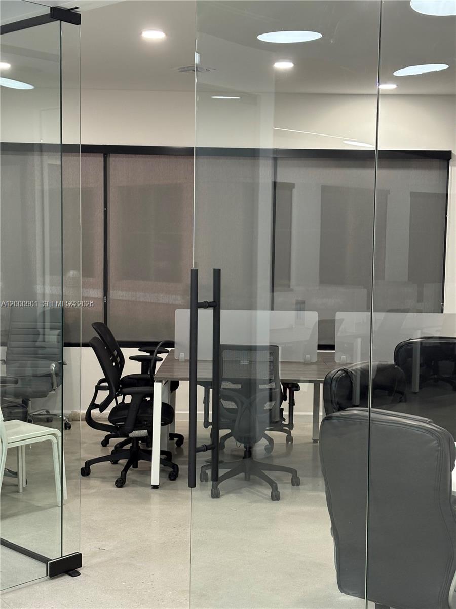 A modern office space features glass partitions, ergonomic chairs, and a wooden desk — 1545 N Park Dr, Weston FL 33326, WESTON, FL