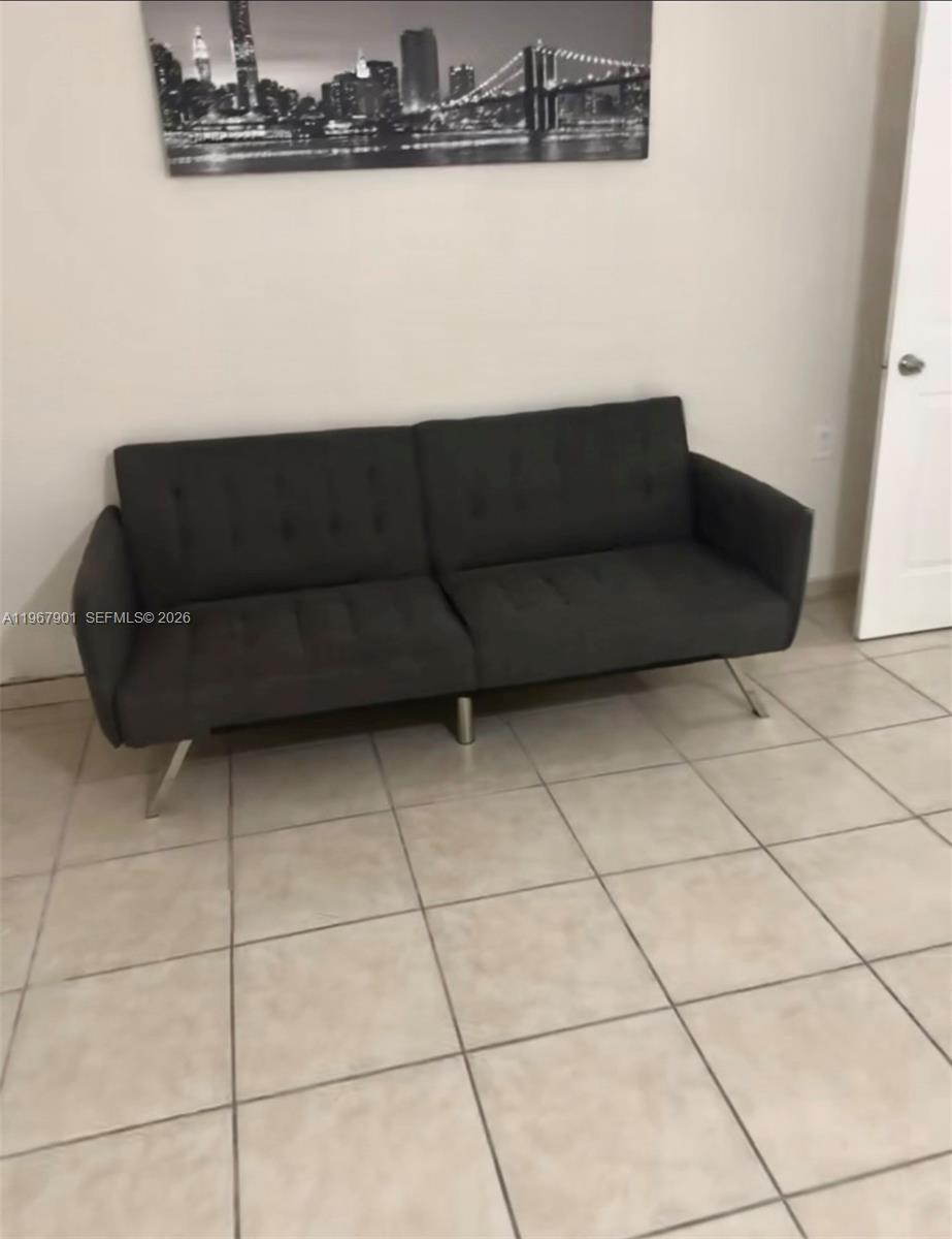 A dark gray sofa sits against a white wall beneath a black-and-white city skyline print — 103xx SW 168th St # 0, Miami FL 33157, MIAMI, FL