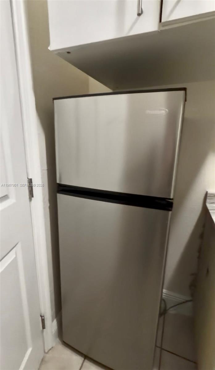 A stainless steel top-freezer refrigerator stands in a kitchen next to a white door — 103xx SW 168th St # 0, Miami FL 33157, MIAMI, FL