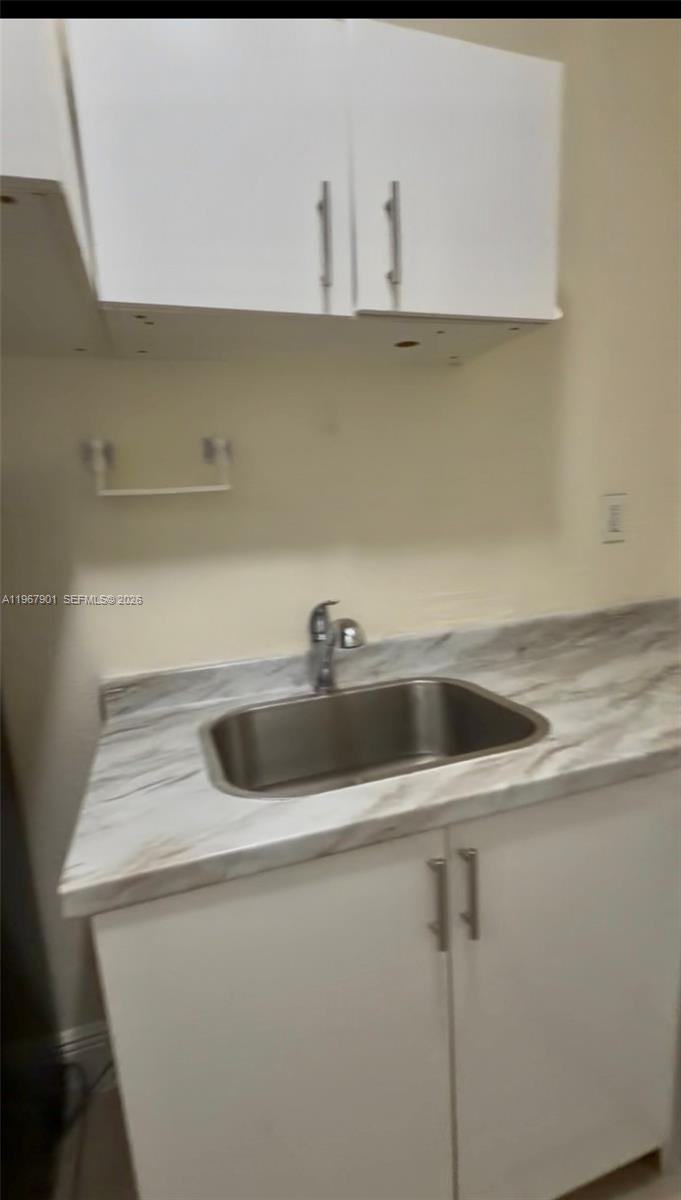 A kitchen area features white cabinets, a stainless steel sink, and a marble-patterned countertop — 103xx SW 168th St # 0, Miami FL 33157, MIAMI, FL